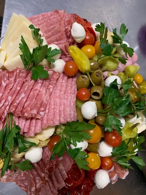 An antipasto platter with cured meats, cheeses and olives