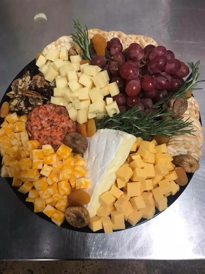 A premium cheese platter with grapes and dried fruit