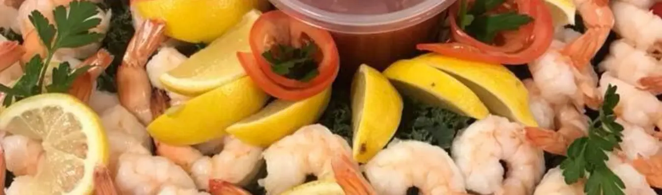 A shrimp platter with lemon wedges