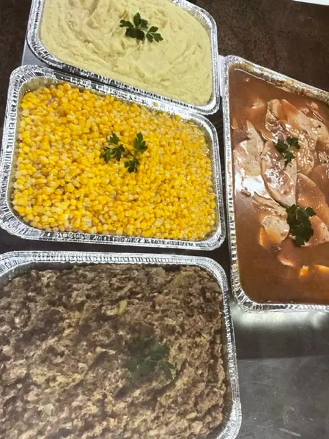 Catering trays of mashed potatoes, corn and stuffing