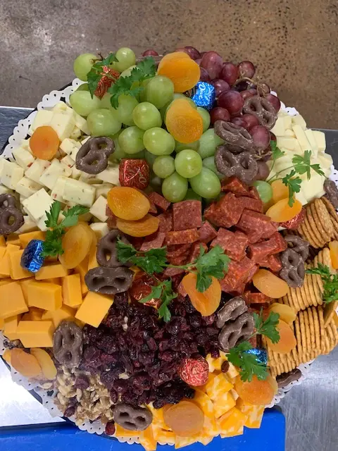 A cheese and fruit platter with grapes and crackers