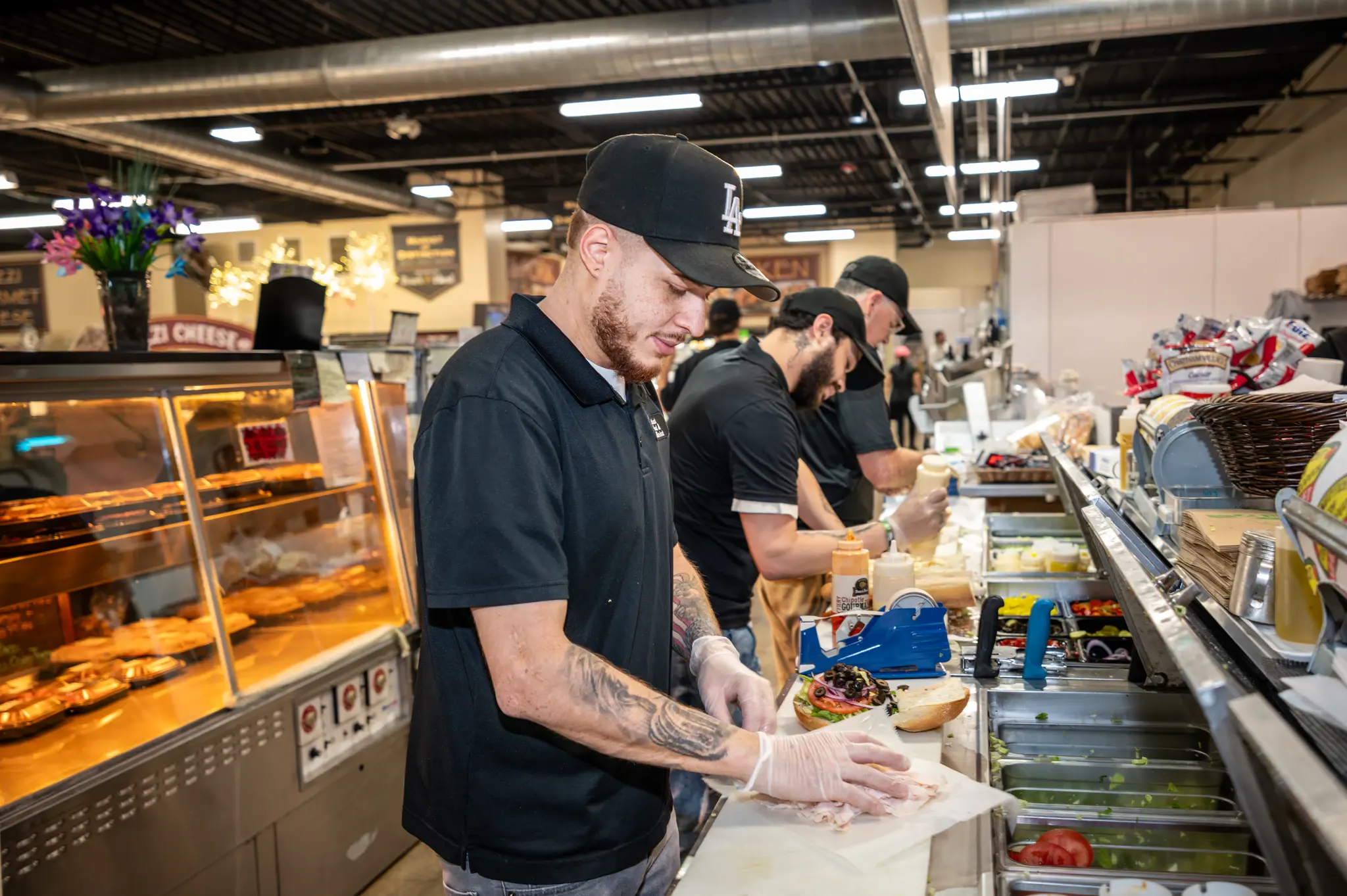 Staff building sandwiches to order on the deli line