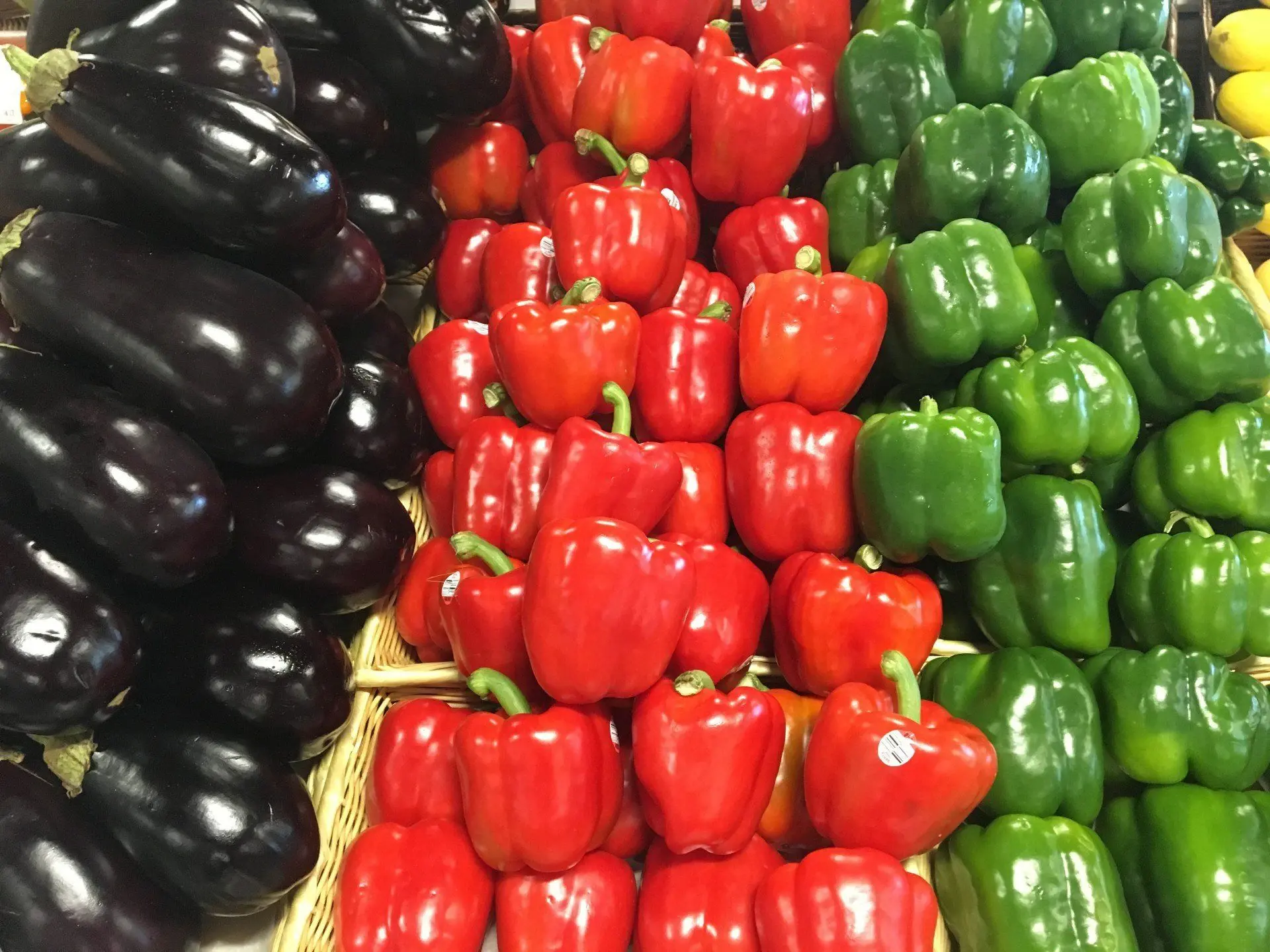 Eggplant and red and green peppers on display