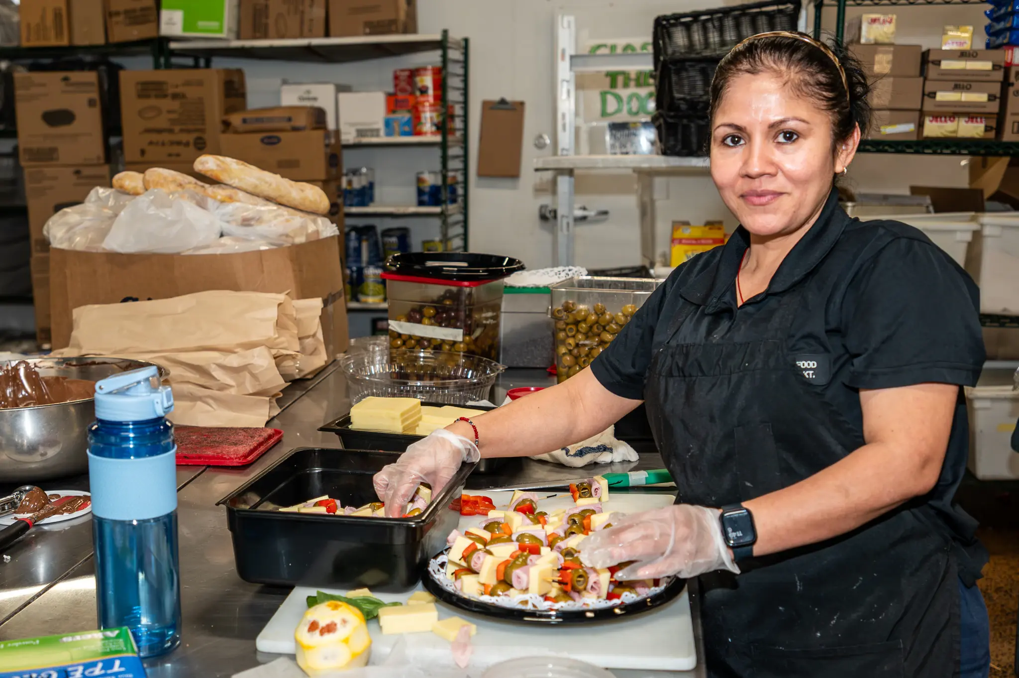 A staff member arranging a catering platter in the kitchen