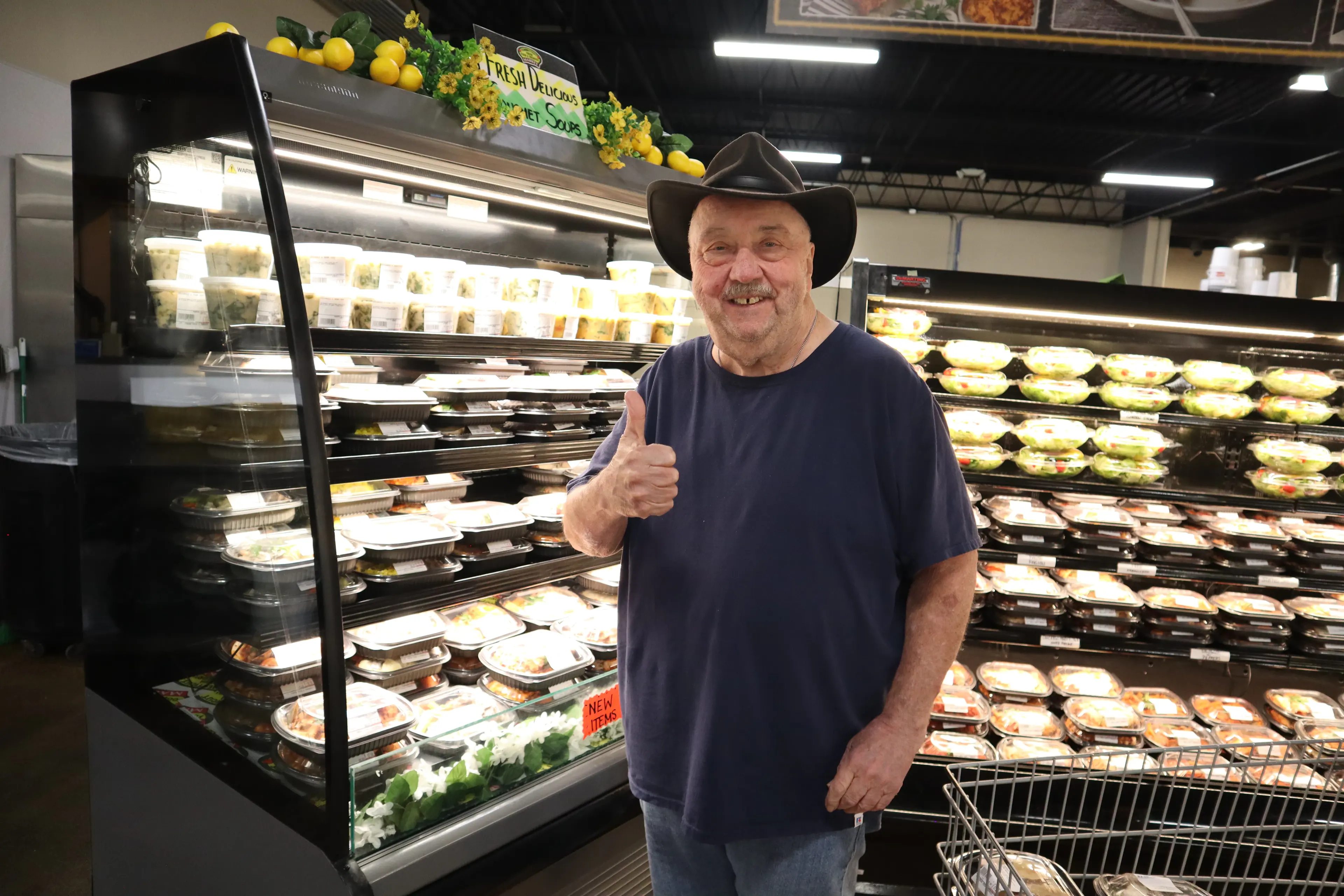 A staff member behind the prepared foods case